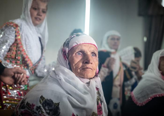 An elderly woman watches on as the wedding horo dance progresses