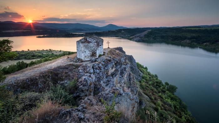 Sunset over dam with church, Bulgaria